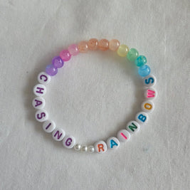 Chasing Rainbows beaded bracelet with colorful rainbow beads and letter beads on white background