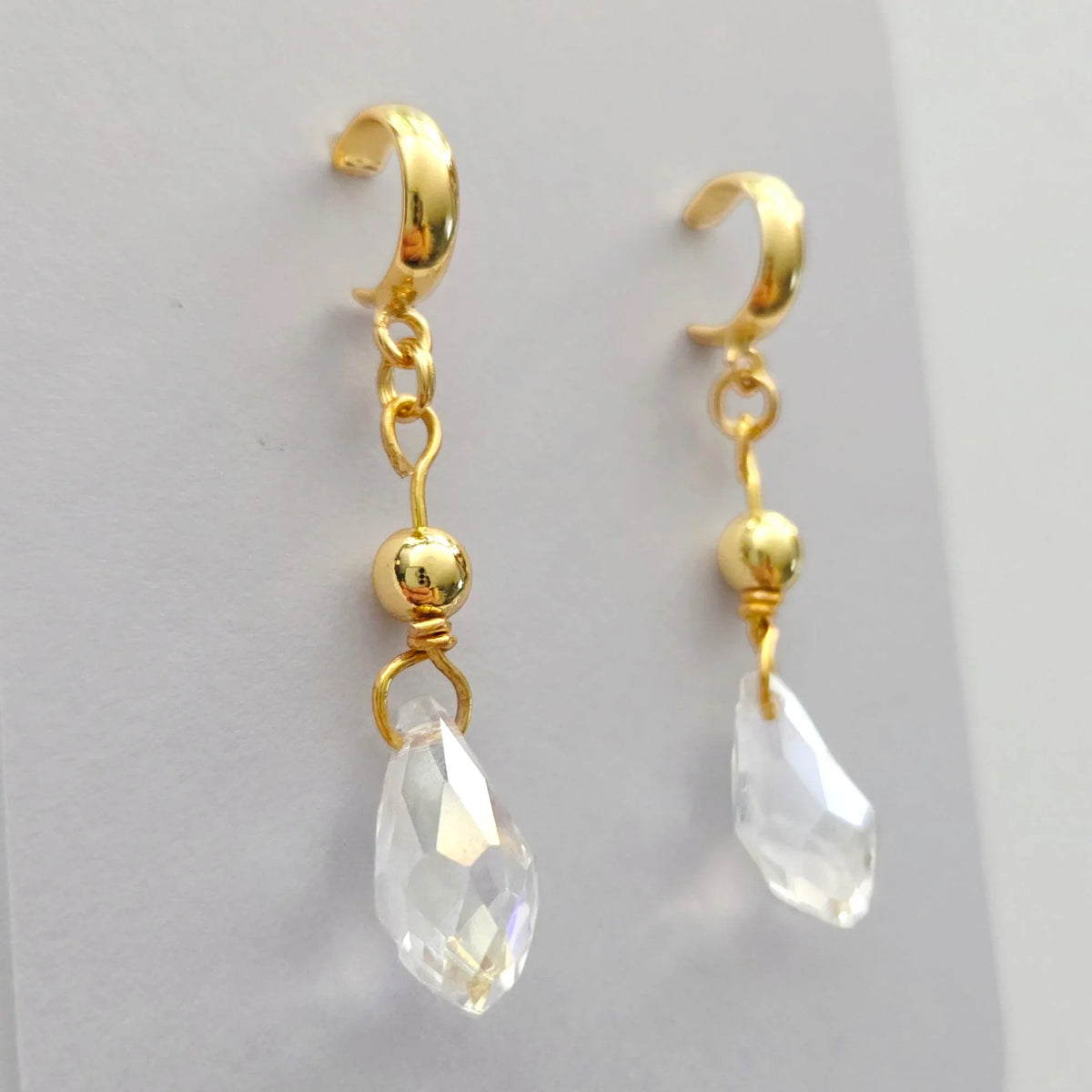 Handmade by Erika Liesel gold half-hoop drop earrings featuring faceted clear crystal beads and 18k gold accents.