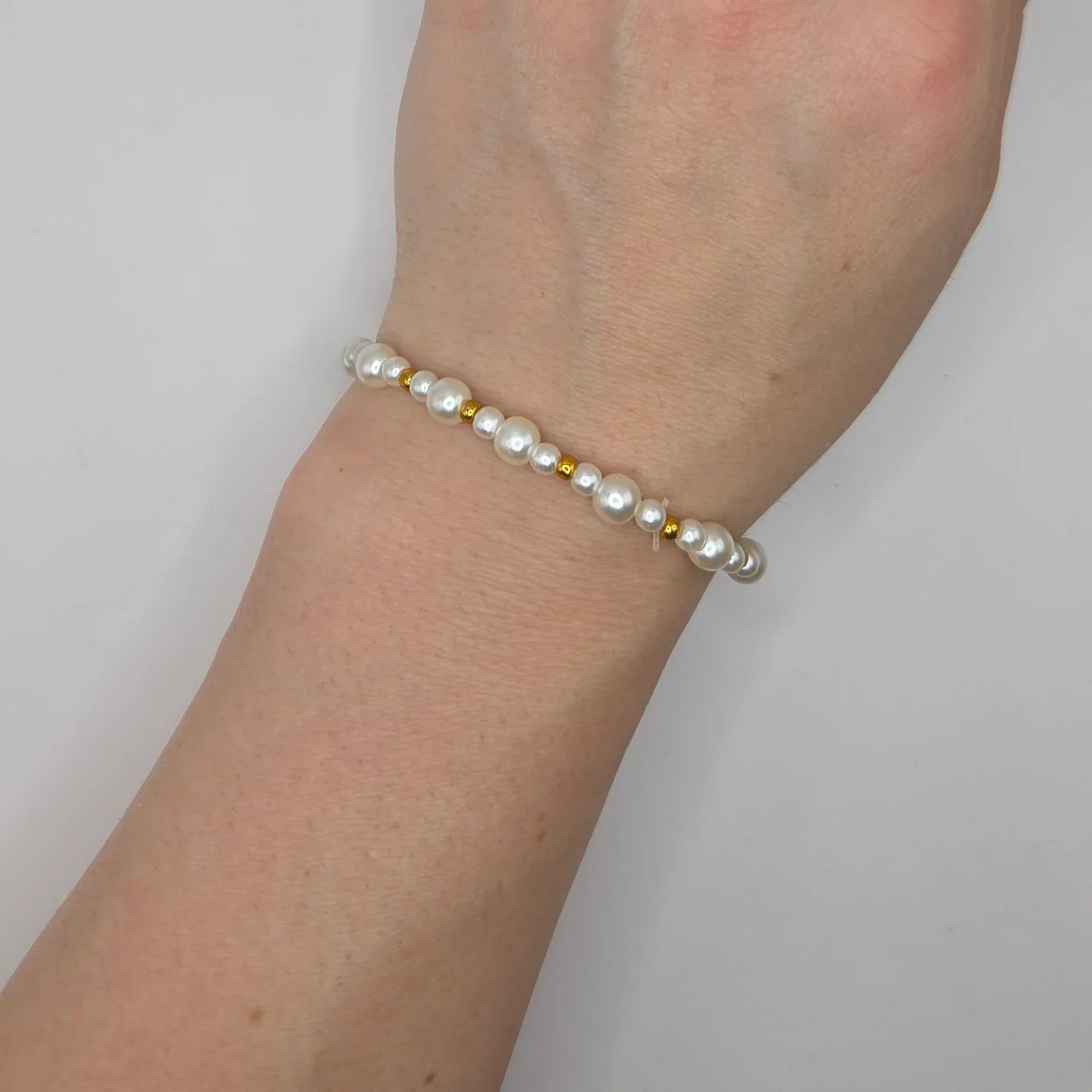 Delicate pearl bracelet with gold beads, handmade for everyday elegance and comfort.