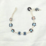 Handmade crochet necklace with blue and beige flower beads, macrame cord, and wooden toggle clasp