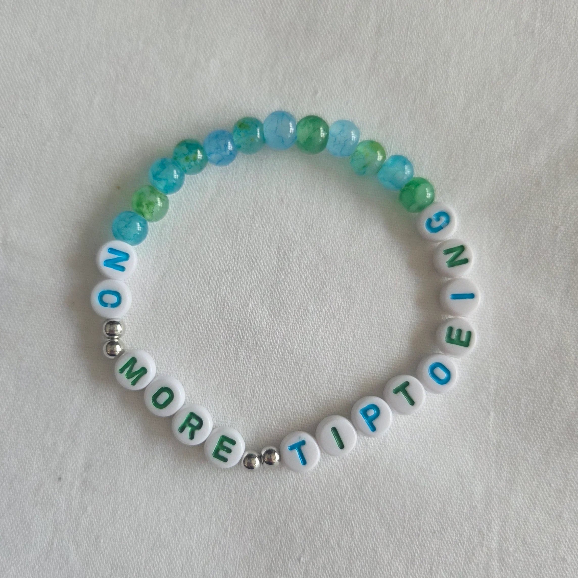 No More Tiptoe beaded bracelet with blue and green marbled beads on white background