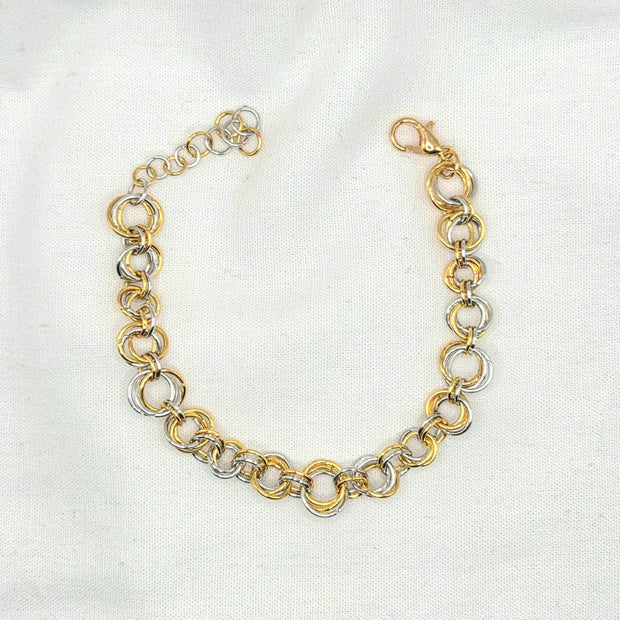 Two-tone gold and silver chainmaille bracelet with lobster clasp on white fabric