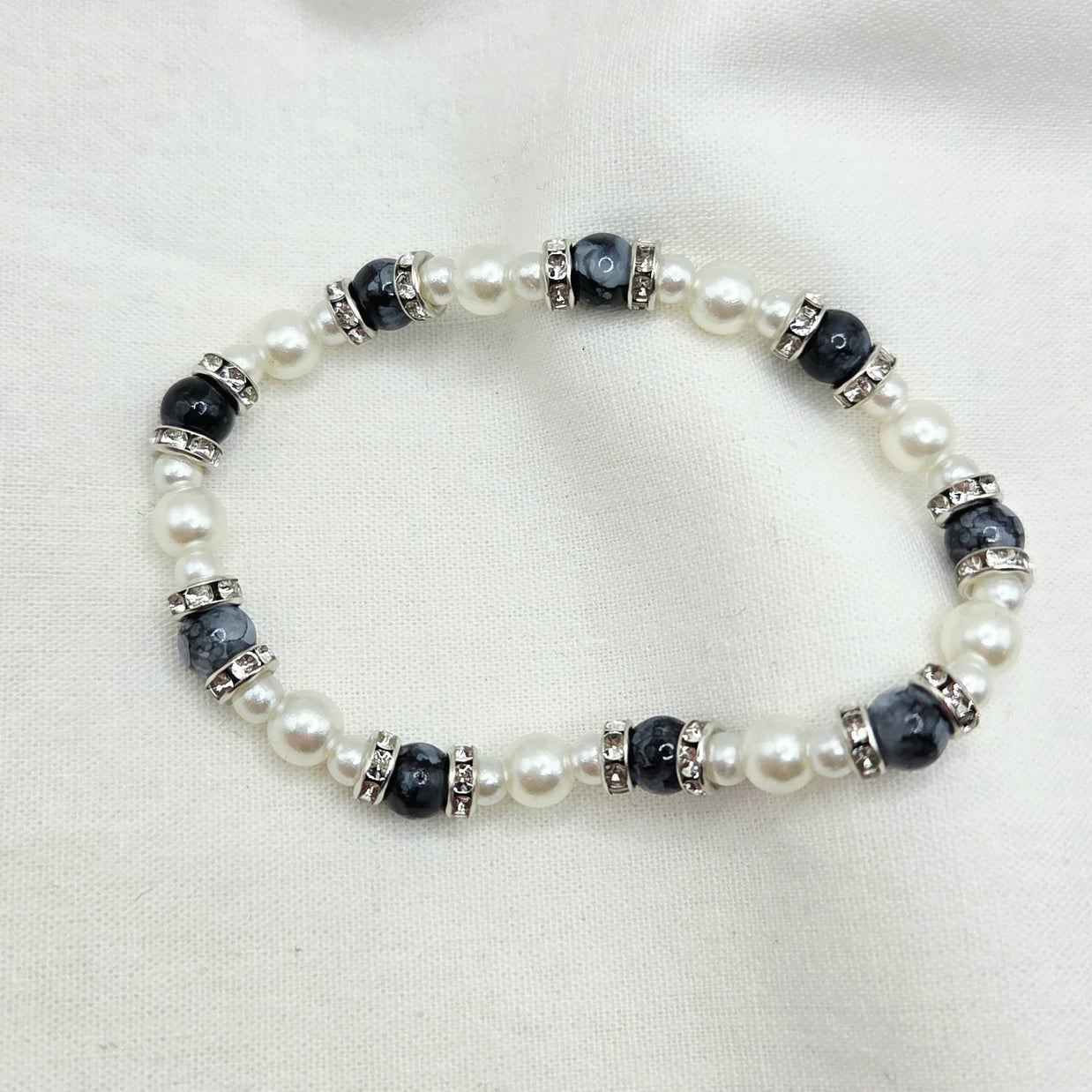Elegant pearl and black bead bracelet with crystal accents, perfect for cozy handmade gifts