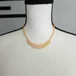 Gold chainmaille necklace with interlocking rings displayed on mannequin, handmade jewelry for everyday wear