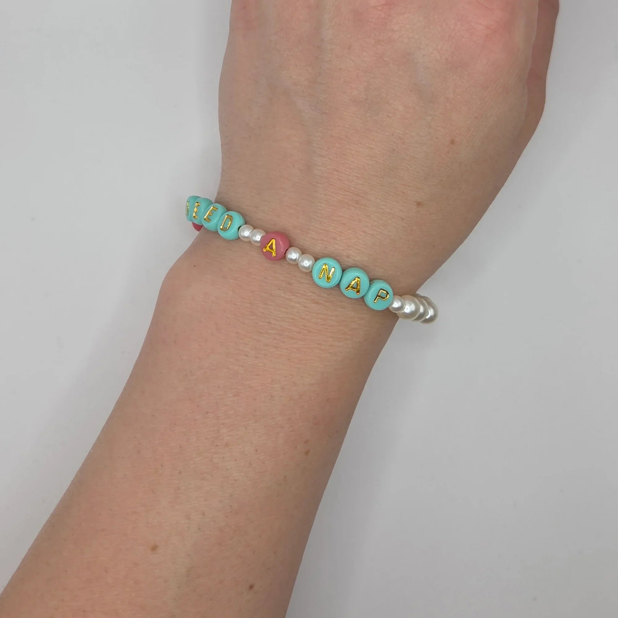 Handmade 'Need a Nap' beaded bracelet with mint, pink, and pearl beads on wrist