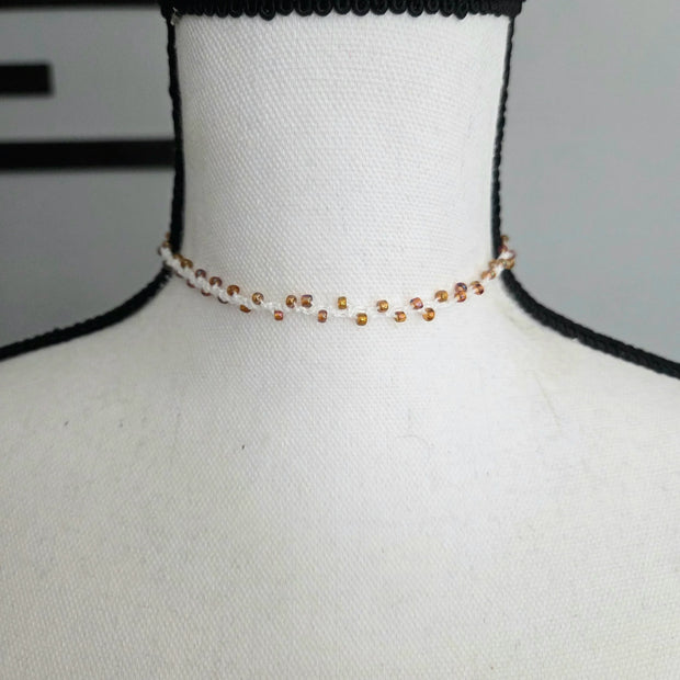 Handmade crochet choker necklace with amber beads on white mannequin, cozy boho style accessory