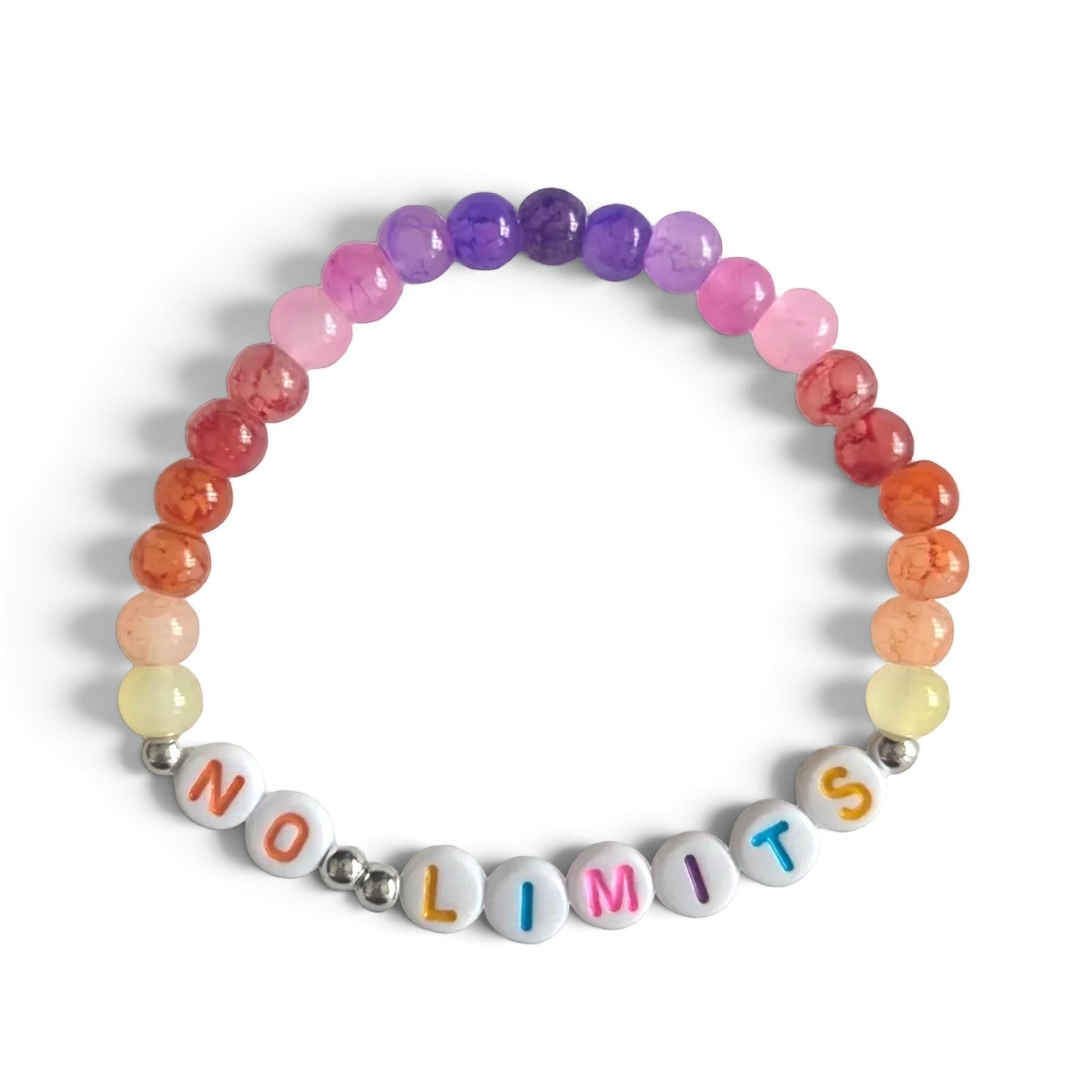 Colorful beaded bracelet with 'NO LIMITS' letter beads, rainbow gradient stones, and silver spacers on white fabric.